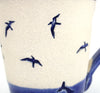 Coastal themed pottery, high fired stoneware mug with a hand etched design of gulls diving into the water. Close up of artwork
